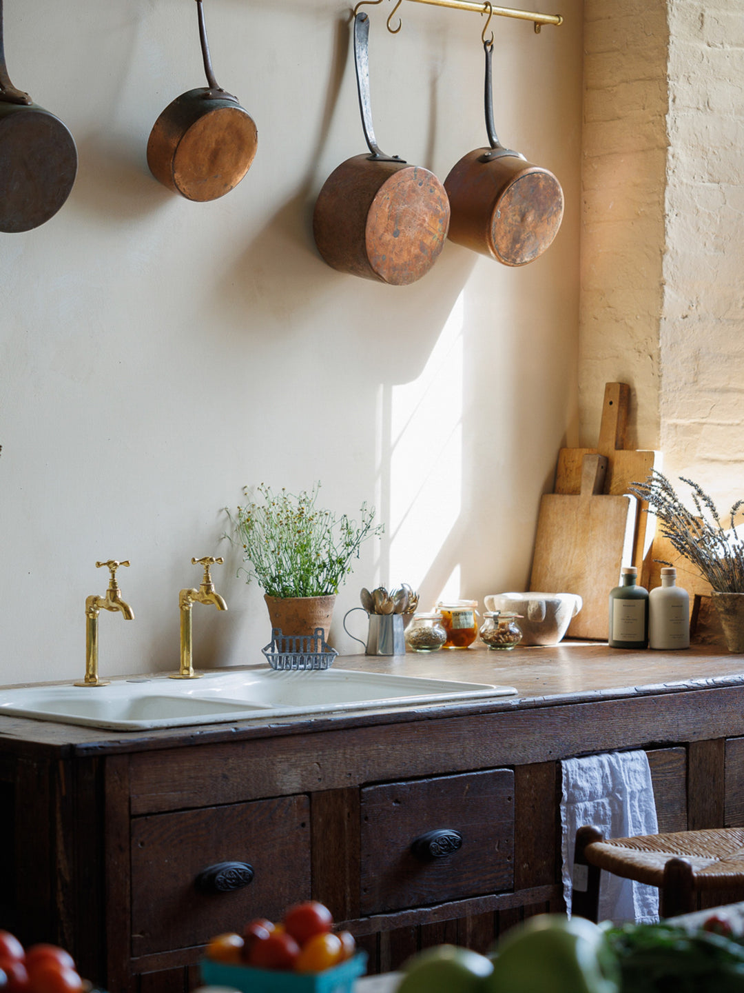 a kitchen with copper pots and pans hanging from the wall