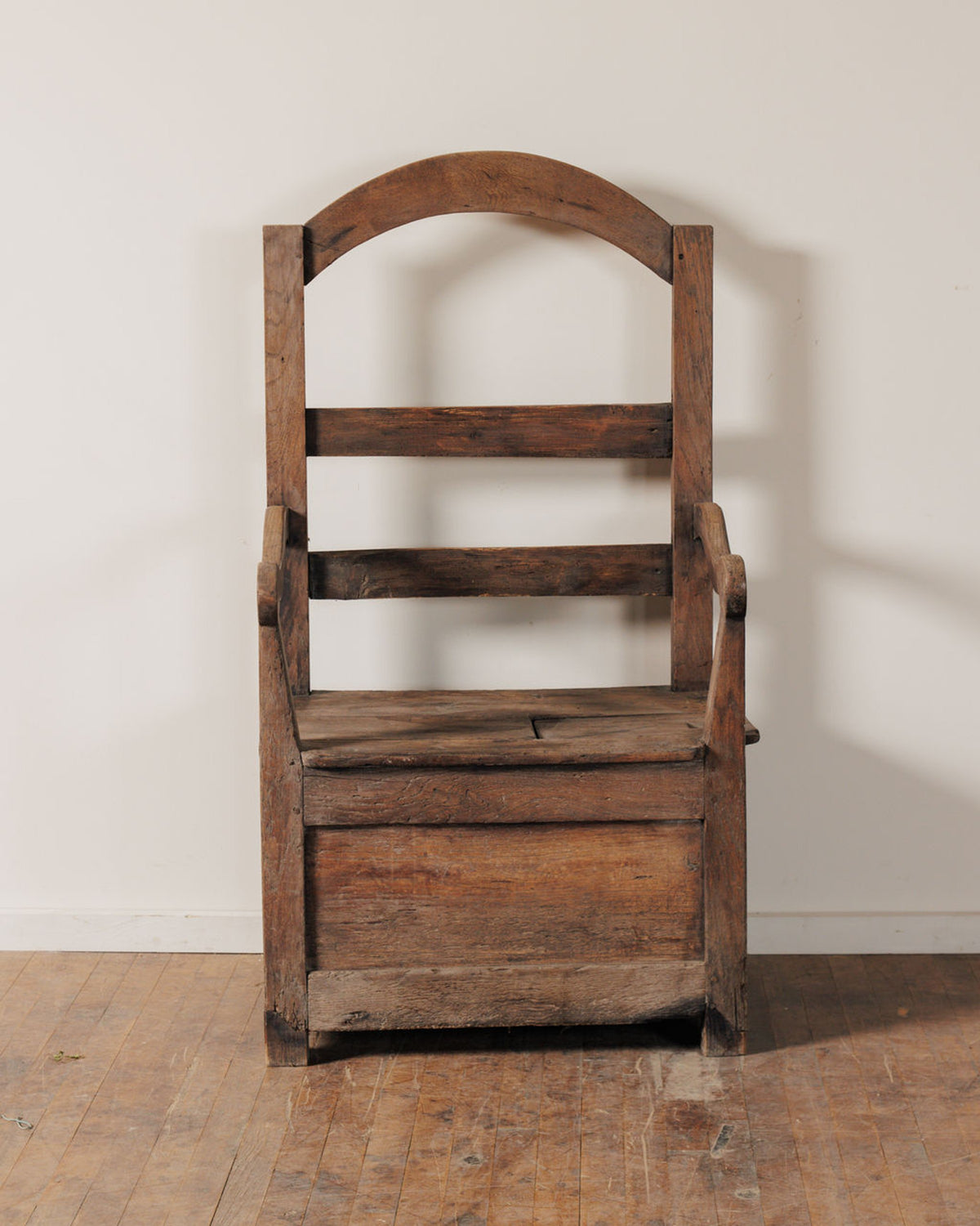 Rustic wooden storage chair with an arched back.
