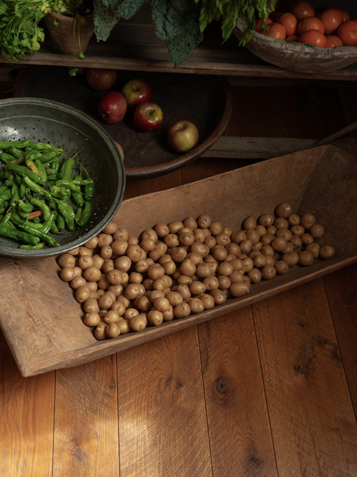 a Turkish dough bowl filled with potatoes next to a bowl of shishito peppers